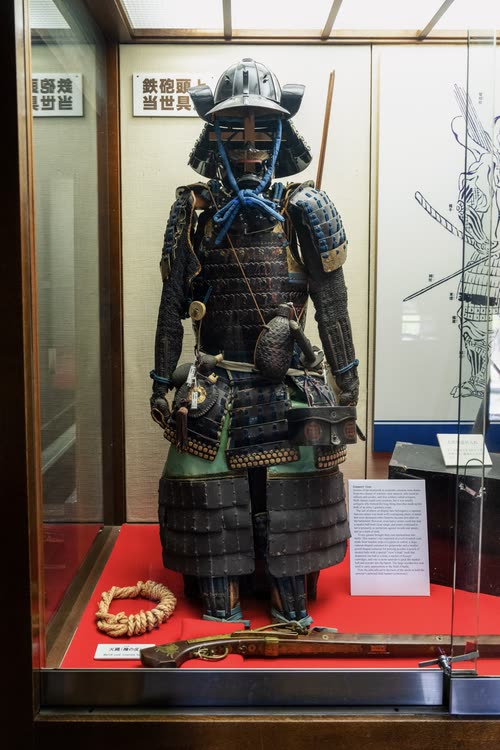 A suit of samurai armour displayed in a glass museum case