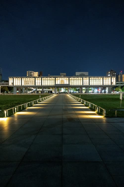 The Peace Memorial Museum lit at night at the end of the park's central walkway, Hiroshima