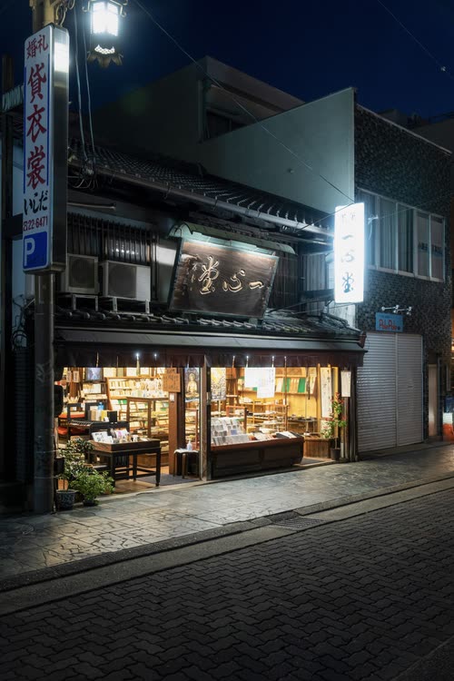 A traditional shopfront lit warmly on a dark street in Nara