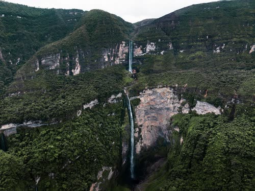 The tiered drop of Gocta Falls plunging down a forested cliff in northern Peru