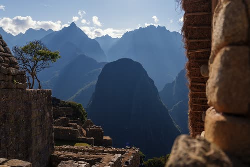 The peaks of the Urubamba range framed through an Inca stone window at Machu Picchu