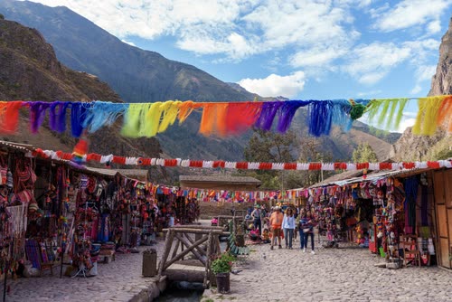 Textile stalls and bunting lining the market street at Ollantaytambo, Peru