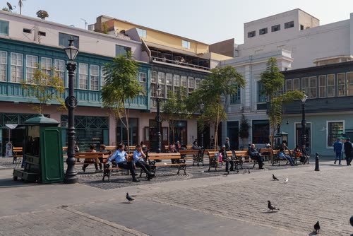 Palms and painted balconies around a public square in Lima