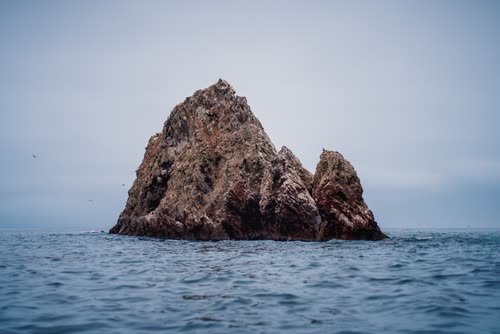 A jagged rock stack rising from the Pacific off the Paracas coast