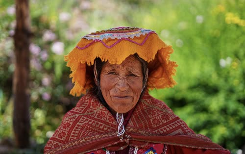 Portrait of a Quechua woman in a woven hat and red shawl, Peru