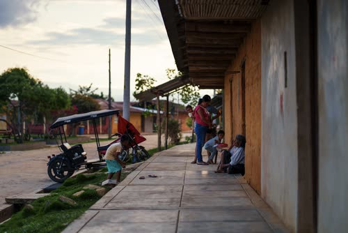 A motorcycle taxi parked on a village street at dusk in northern Peru