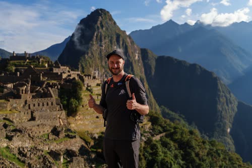 Jordy Scott at Machu Picchu with Huayna Picchu rising behind him