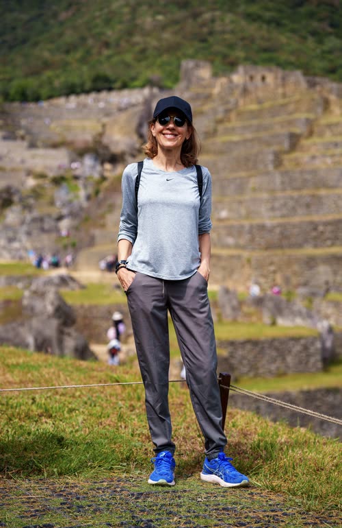 A woman standing before the terraces of Machu Picchu