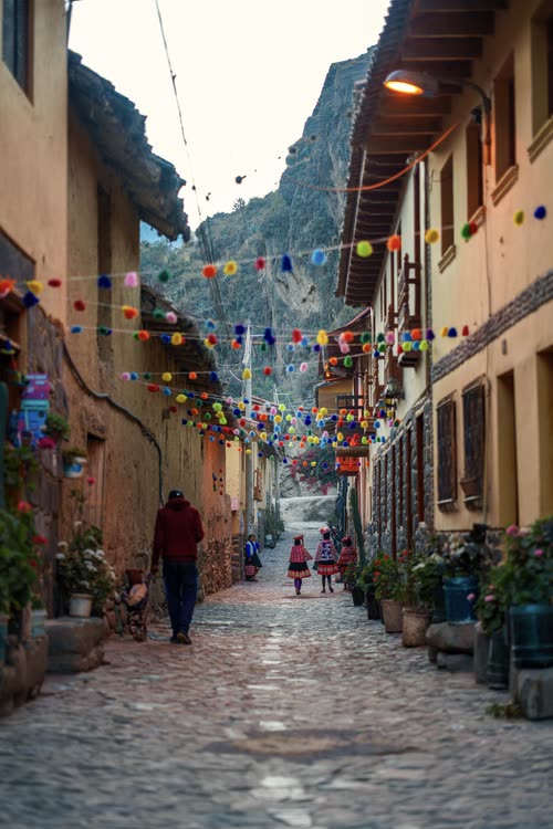 A narrow Ollantaytambo lane strung with festival bunting between adobe houses