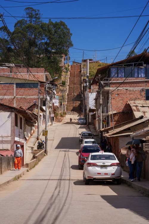 A steep street of brick and tin-roofed houses climbing an Andean hillside