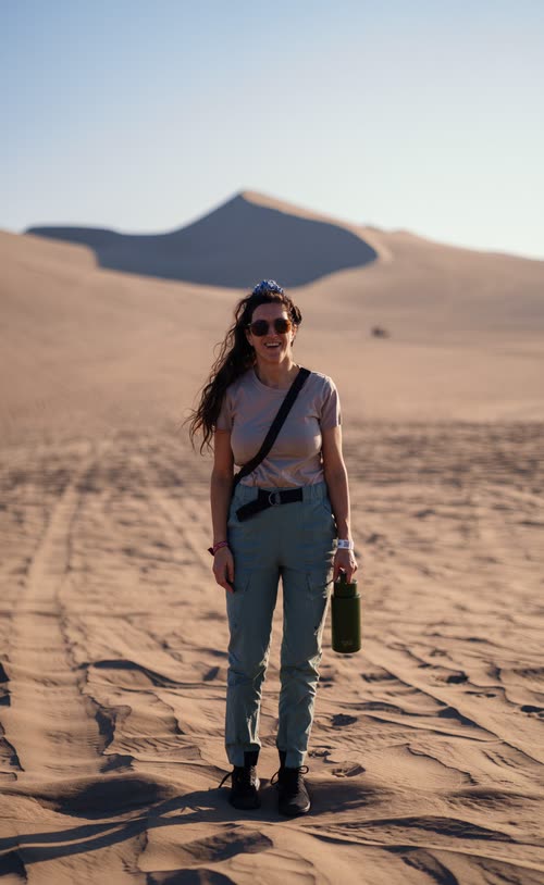 A woman standing on the dunes at Huacachina in late afternoon light