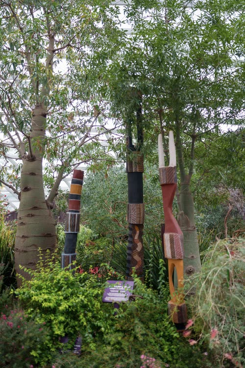 Painted totem poles standing among baobabs in the Flower Dome, Singapore