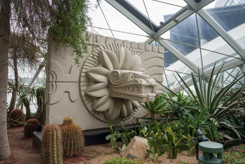 A carved serpent relief among cacti in the Flower Dome, Gardens by the Bay