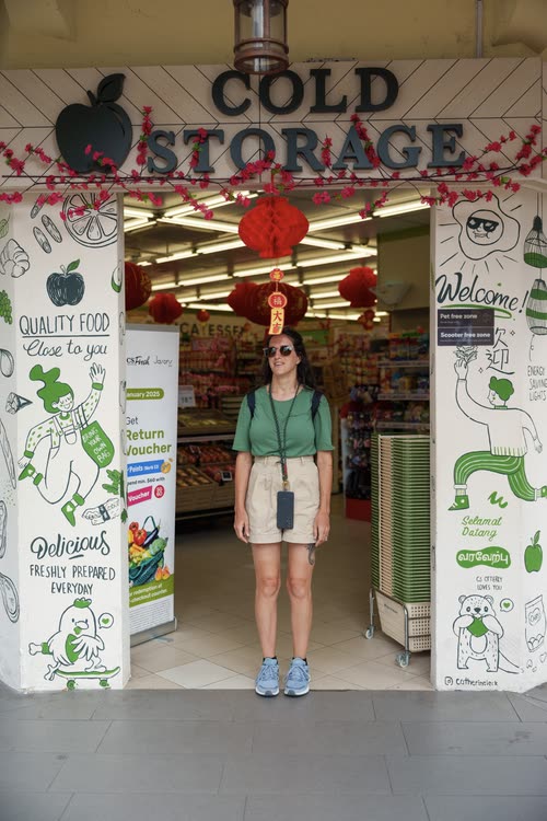 A woman standing in the doorway of a Cold Storage supermarket, Singapore