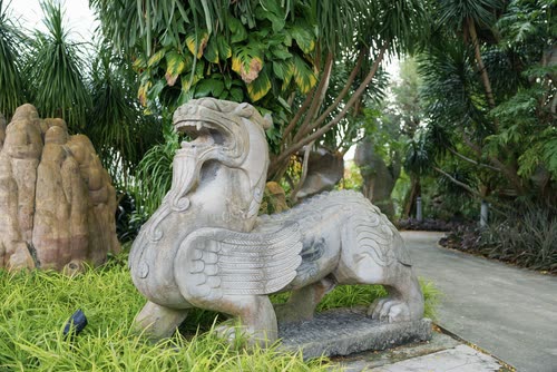 A carved stone mythical beast in a tropical garden, Singapore