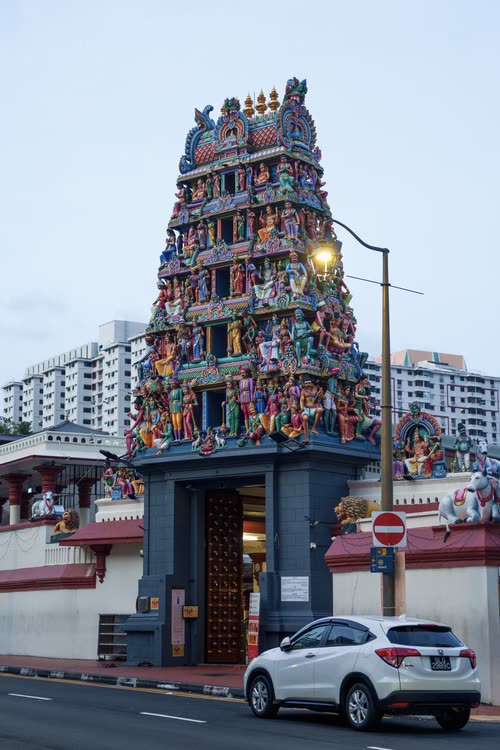 The sculpted gopuram tower of a Hindu temple rising above the street, Singapore