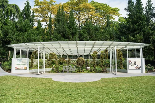 A glasshouse pavilion on a lawn in the Singapore Botanic Gardens