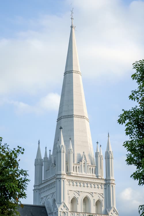 The spire of St Andrew's Cathedral against a blue sky, Singapore
