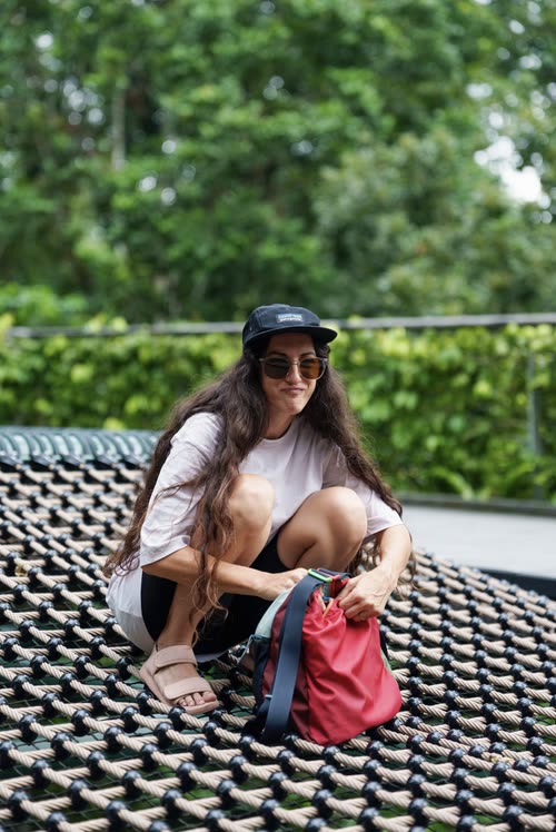 A woman sitting on a tiled roof terrace surrounded by greenery, Singapore
