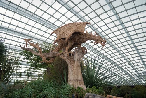 A large driftwood creature sculpture beneath the conservatory glass, Singapore