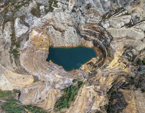 Aerial view of a flooded open cut mine pit in western Tasmania