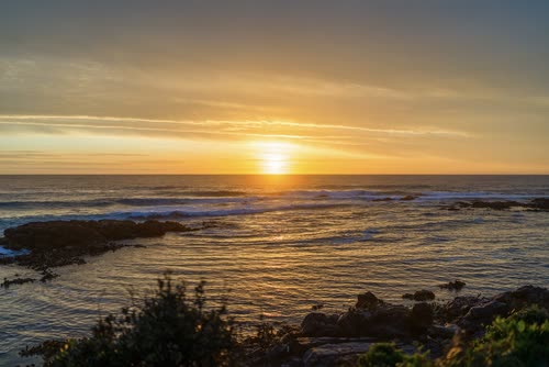 Sunrise over the rocks and surf on the east coast of Tasmania