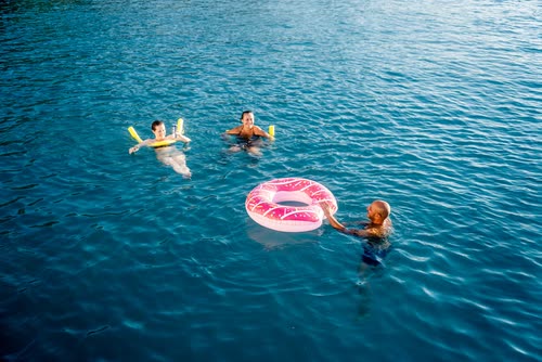 Swimmers on inflatable rings in deep blue water, Turkey