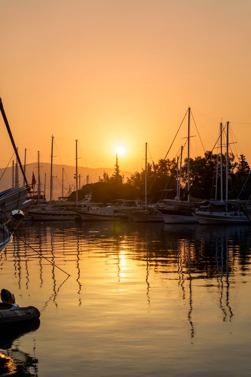 The sun rising over the yachts and masts of a Turkish harbour