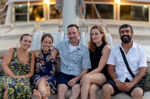 Five travellers seated together on a gulet deck in the evening, Turkey