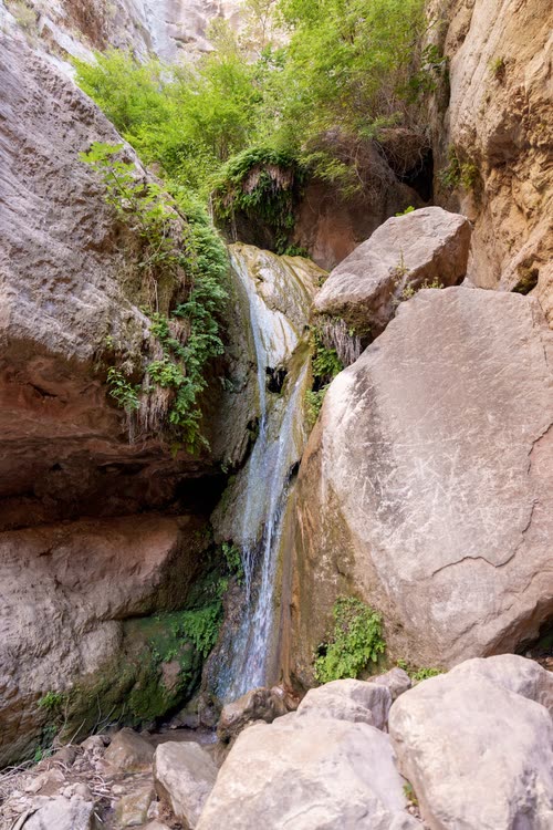 A thin waterfall running between pale boulders in Saklikent Gorge, Turkey