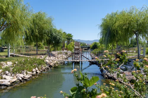 A footbridge and willows over a canal in a Turkish park