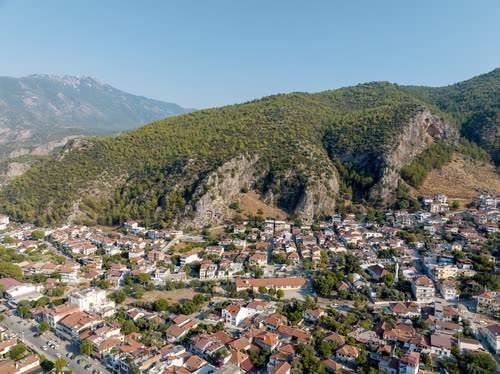 Aerial view of a Turkish town below steep forested mountains