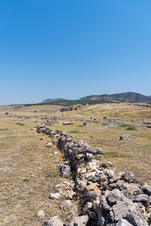 A low ruined wall running across open ground at Hierapolis, Turkey