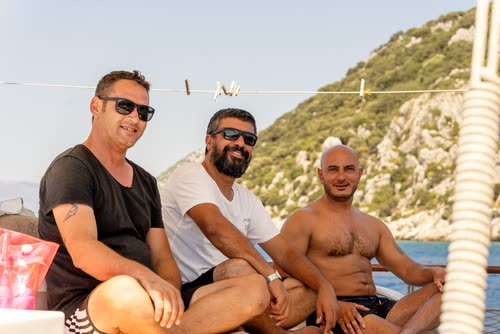 Three men sitting together on the deck of a gulet, Turkey