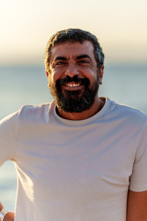 Portrait of a smiling bearded man against the sea, Turkey