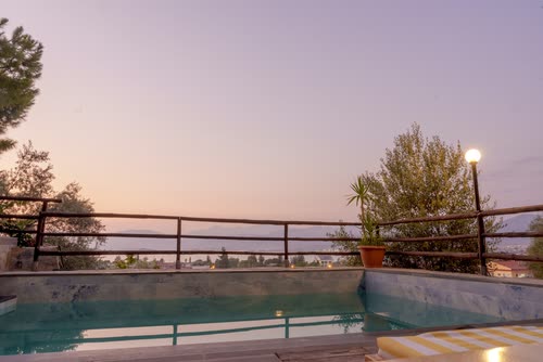 A swimming pool and terrace above the valley at dusk, Turkey
