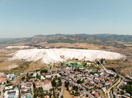 Aerial view of the white travertine hillside above the town at Pamukkale, Turkey