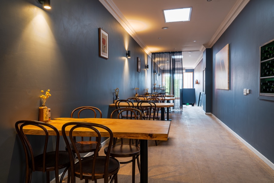 The dining room of a wine bar in deep navy with bentwood chairs