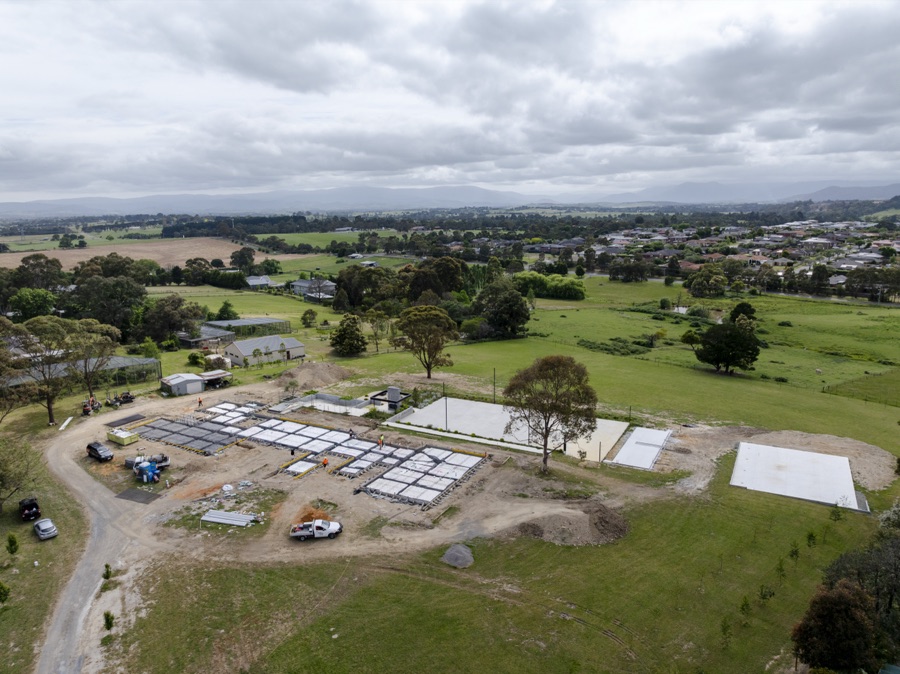 Aerial of a cleared subdivision with the slab grid laid out below the treeline