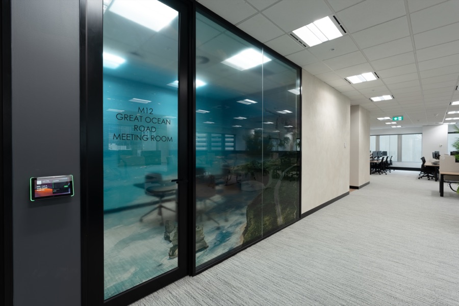 Glass partitioned offices along a lit corridor