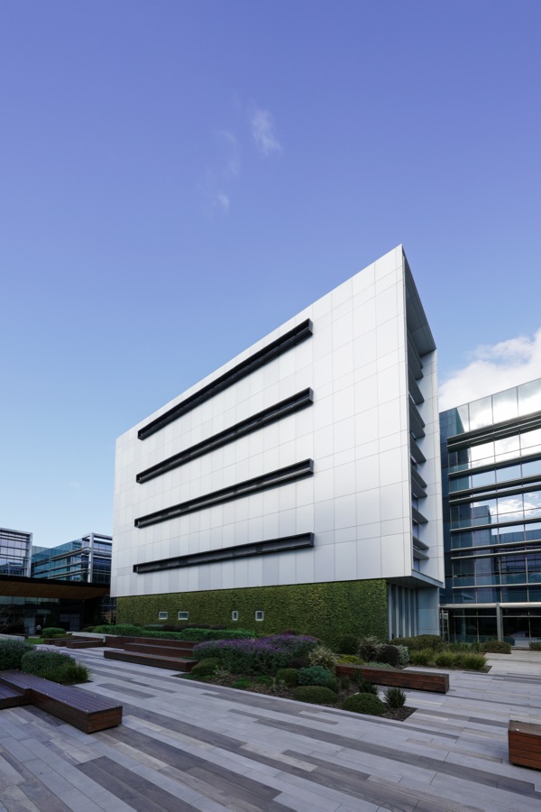 Angular white facade of a commercial building above landscaped terraces