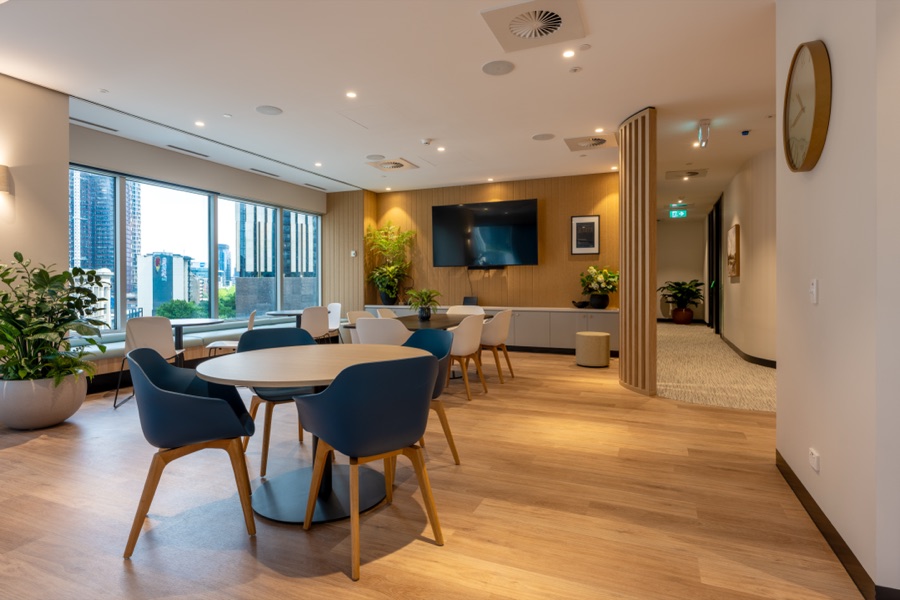 Breakout lounge with blue chairs and a city outlook