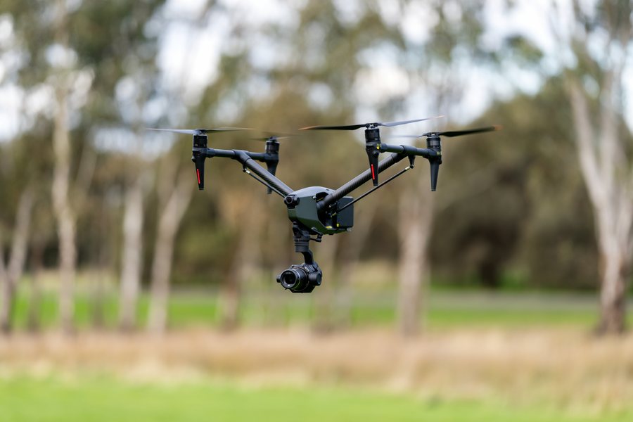 A DJI Inspire cinema drone in flight with its gimbal camera facing down