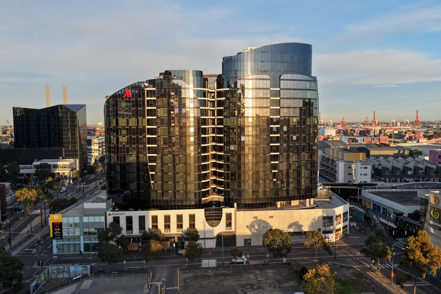Curved glass apartment tower photographed from the air in Port Melbourne