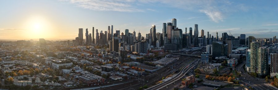 Wide aerial panorama of the Melbourne skyline shot into the morning sun