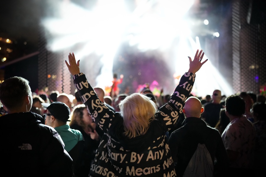 Crowd with hands raised in the lights at a live show