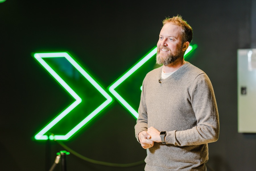 Speaker presenting in front of an illuminated venue sign