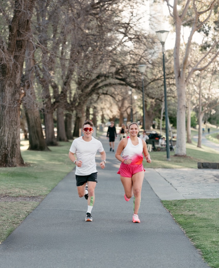 Two runners on a tree lined path in winter