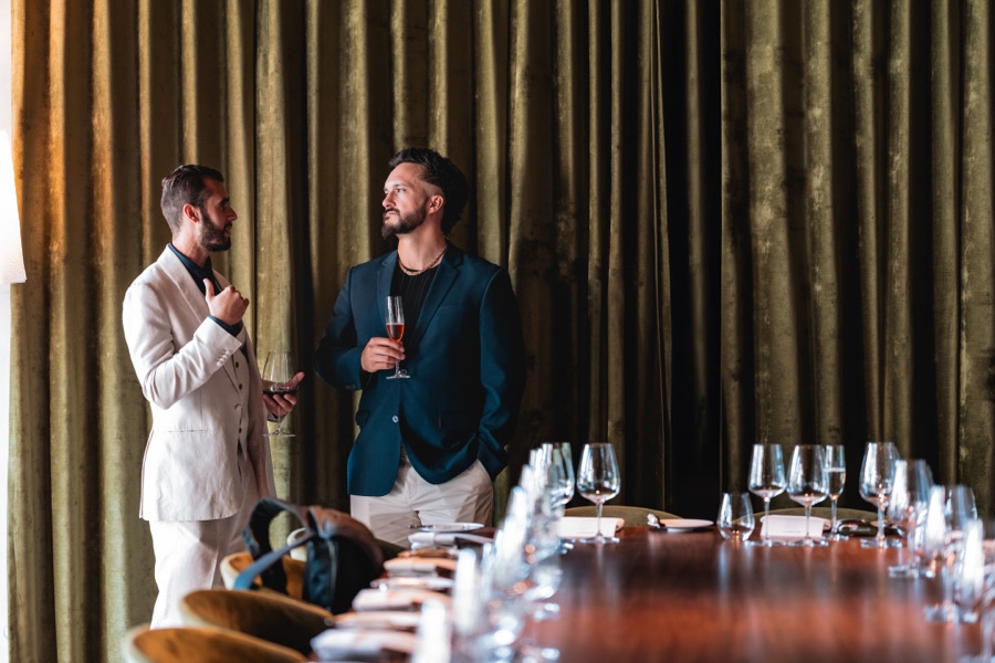 Two guests at a table set with wine glasses