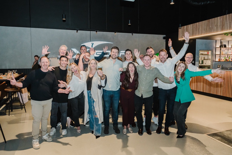 Group celebrating with arms raised at an indoor event